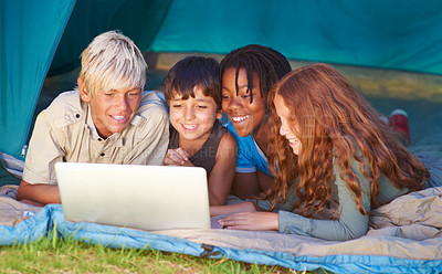 Buy stock photo Children enjoying using a laptop while out camping in a tent