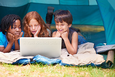 Buy stock photo Children, face and watching with laptop in tent for camping, social media and movie with diversity in nature. Friends, cartoon and group with smile outdoor on grass for travel, relax and holiday fun