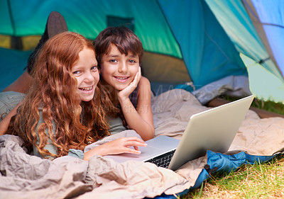 Buy stock photo Children, portrait and happy with laptop in tent for camping, social media or online movie with vacation in nature. Family, face and siblings or smile outdoor on grass for trip, relax and holiday fun