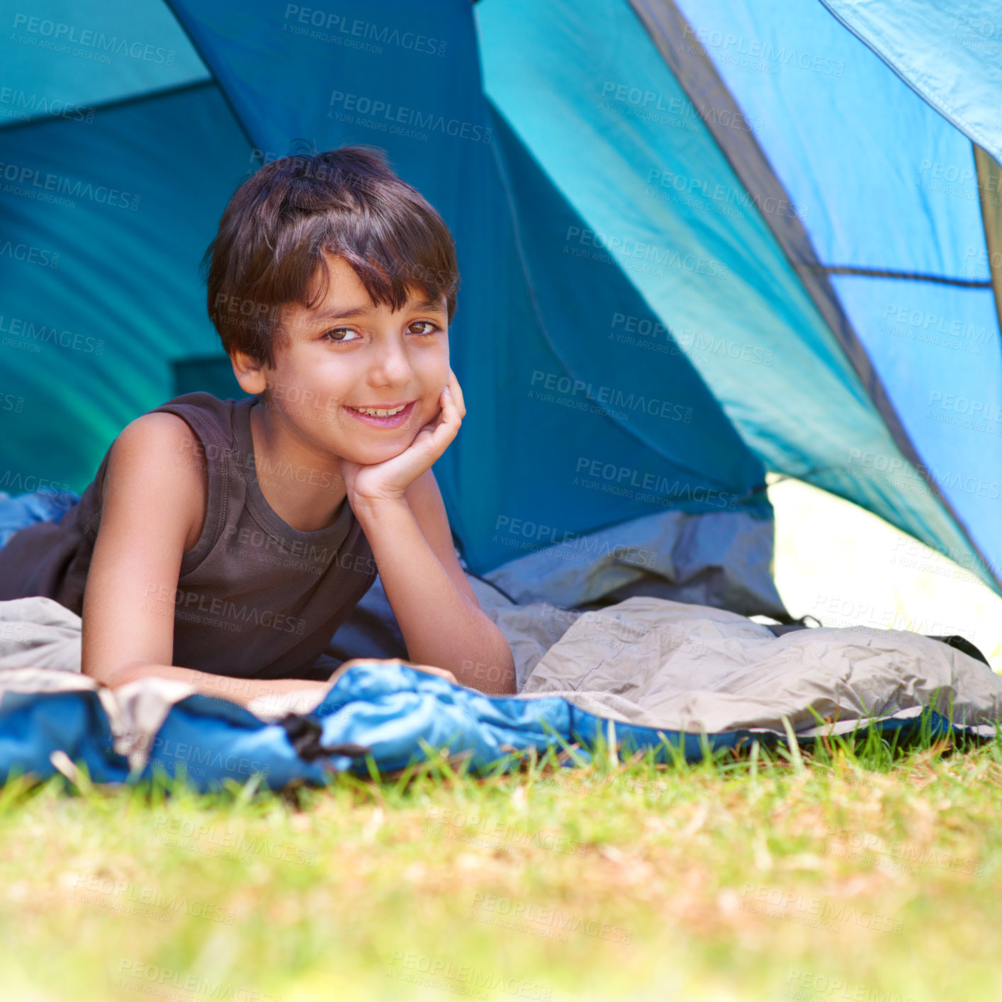 Buy stock photo Boy, child and camping, relax in tent and summer vacation with travel and happy in portrait outdoor. Rest on sleeping bag, young camper with smile and adventure in nature, childhood and recreation