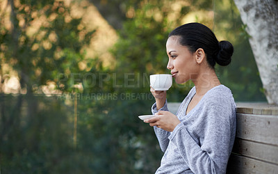 Buy stock photo Shot of a a young ethnic girl enjoying a cup of coffee outside