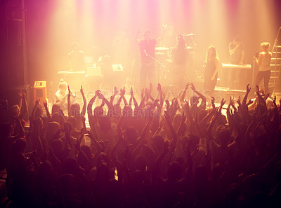 Buy stock photo Concert, audience and rock music with hands up from people at dj, band and festival event at a stage with lights. Show, dance and party with excited crowd in rave, techno and entertainment at venue