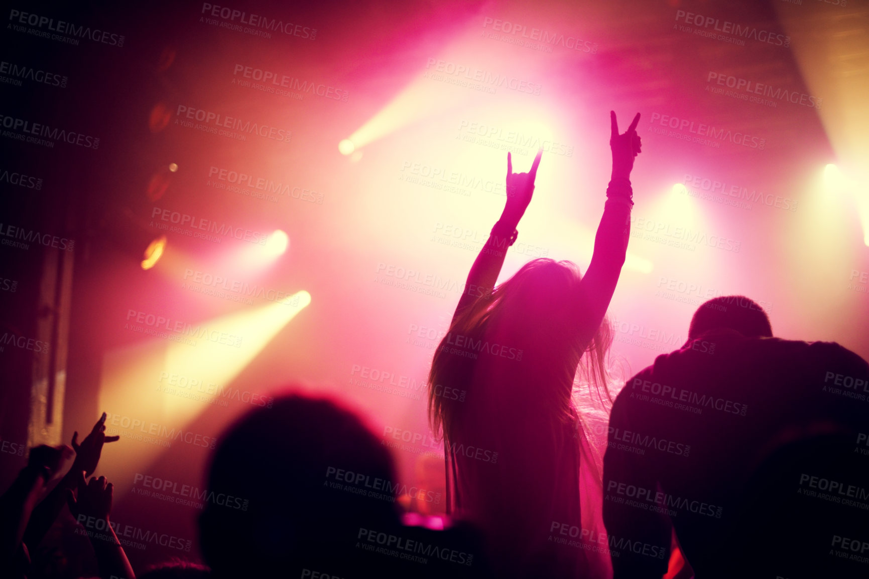 Buy stock photo Rock, concert and people dance at night, event or party at music festival with fans in audience at stage. Crowd, energy and woman with hands in sign for metal, sound or social celebration at rave