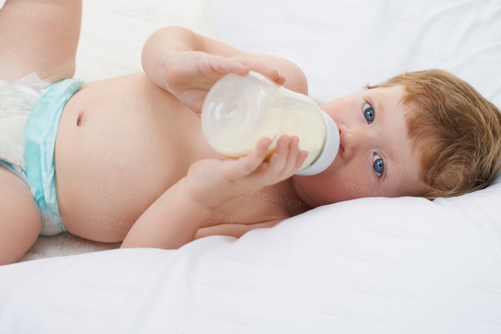 Buy stock photo Portrait, bottle and baby in bed drinking milk for meal, feeding or food lying down in home. Hungry child, wellness and healthy boy toddler with formula for nutrition, natural diet or growth alone