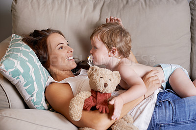 Buy stock photo A young mother lying on the sofa with her baby boy