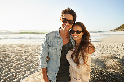 Buy stock photo Shot of a beautiful young couple standing side by side on the beach