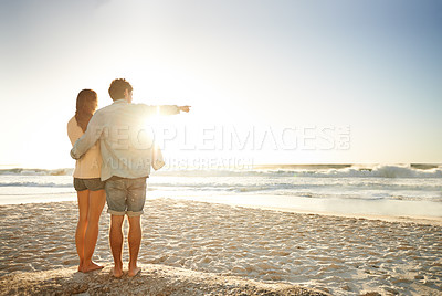 Buy stock photo Hand pointing, sunset beach and back of couple in nature with hug, support or love. Summer, romance and people at sunrise with ocean view, conversation or mockup on vacation, holiday or Florida trip
