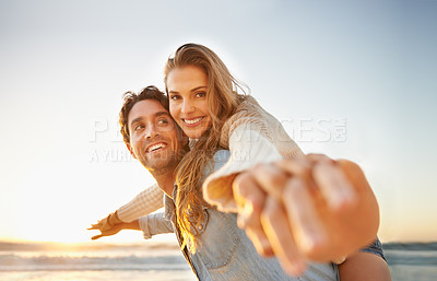 Buy stock photo A blissful young couple celebrating their love on the seashore together