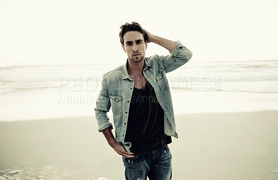 Buy stock photo Man, portrait and fashion on beach vacation, confidence and relaxing at sea on summer holiday. Male person, serious face and denim outfit in Netherlands, stylish clothing and peaceful ocean in nature