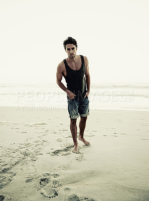 Buy stock photo Cropped shot of a handsome young man on the beach