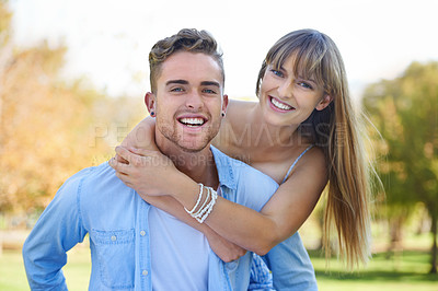 Buy stock photo Shot of a young couple enjoying a day together in a park