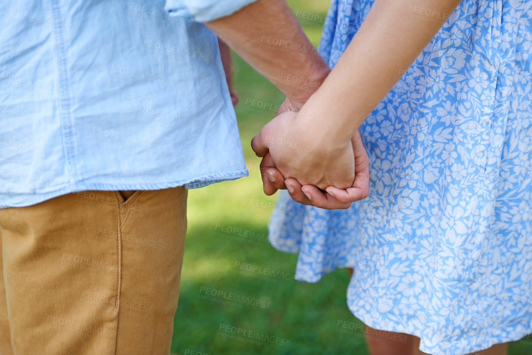 Buy stock photo Cropped shot of a young couple holding hands outside