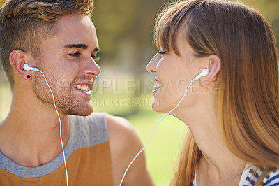 Buy stock photo Outdoor, couple and listening to music with earphones in garden, park or relax in summer with technology. Happy, man and woman hearing radio, audio or streaming podcast together with love in nature