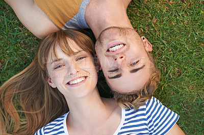 Buy stock photo Portrait of a happy young couple lying in the park