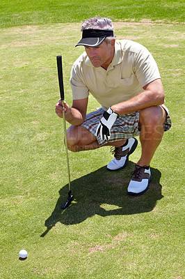 Buy stock photo Mature man, golf and focus on ball on the course for professional game, sports or hobby. Focus, looking and a golfer lining up putt on grass with a club during a competition or match for recreation