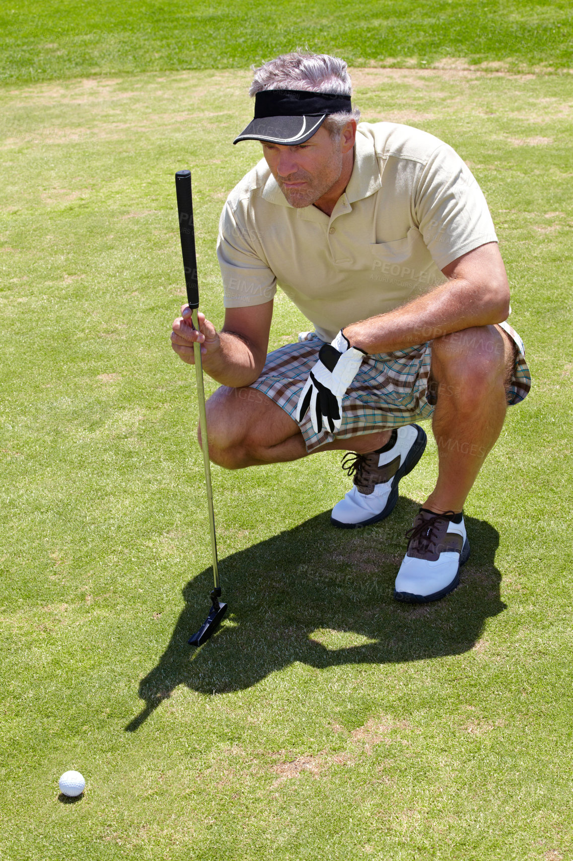 Buy stock photo Mature man, golf and focus on ball on the course for professional game, sports or hobby. Focus, looking and a golfer lining up putt on grass with a club during a competition or match for recreation