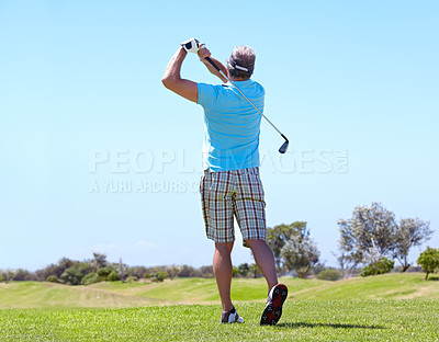Buy stock photo Rearview of a mature male golfer playing a shot