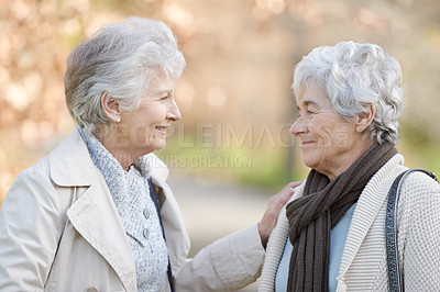 Buy stock photo Senior women, care and touch in park by autumn leaves, together and conversation on retirement in outdoor. Elderly friends, smile or communication on vacation in england, bonding or social in nature