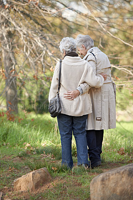 Buy stock photo Senior friends, walk or hugging in nature by autumn leaves, together or care on retirement in park. Elderly women, morning or support on vacation in winter, back or touch in conversation in outdoor