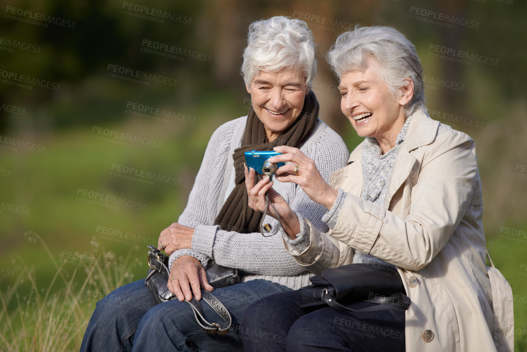 Buy stock photo Senior woman, outdoor and camera with pictures, happy and photography with memories in nature or elderly. Technology, bonding and chatting with friend, funny and laughing together in retirement