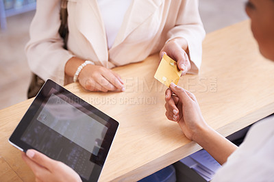 Buy stock photo A young woman handing over her credit card to a salesperson