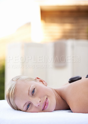 Buy stock photo Spa, woman and hot stone on massage bed with portrait for wellness, mockup and beauty treatment for body care. Person, face and stress relief at resort, salon table and relax on holiday or vacation