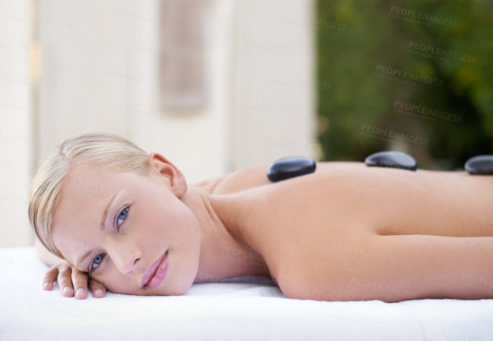 Buy stock photo Woman at spa, hot stone and portrait massage for healing, wellness and holistic treatment at luxury resort. Stress relief, zen and female person with rocks on back in self care or relax muscle heath