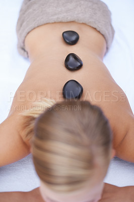 Buy stock photo Woman getting hot stone back massage at spa, holistic treatment and stress relief, self care at luxury wellness resort. Physical therapy, bodycare with rocks for healing and zen with top view