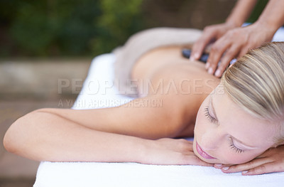 Buy stock photo Woman, massage and hot stones to relax, back and spa for treatment and stress relief therapy. Sleeping, masseuse and wellness in resort, peaceful and hands for luxury bodycare and tranquility