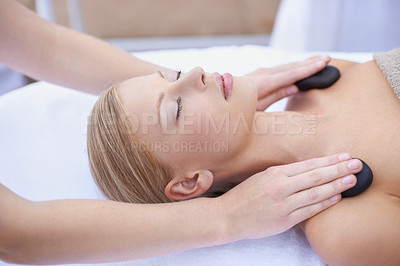 Buy stock photo Woman getting hot stone massage, hands of masseuse in spa and healing holistic treatment with zen at wellness resort. Rocks on shoulders, peace with therapy, alternative medicine and self care