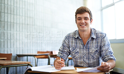 Buy stock photo Student, man and portrait in classroom for education, learning and writing of knowledge in university. Face of young and smart person with notes for college research, essay paper and studying at desk