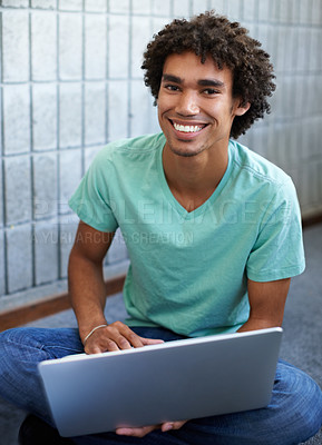 Buy stock photo A handsome young ethnic student sitting with his laptop