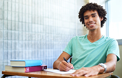 Buy stock photo A young male student sitting in class smiling at the camera