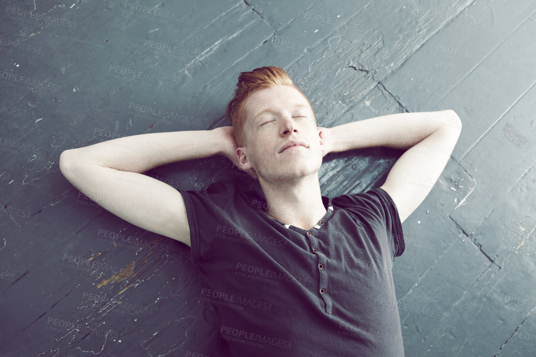 Buy stock photo Relax, overhead and a man lying on the floor, hands behind head to sleep, rest or dream of peace. Quiet, sleeping and lifestyle with a young ginger male person relaxing on the ground from above