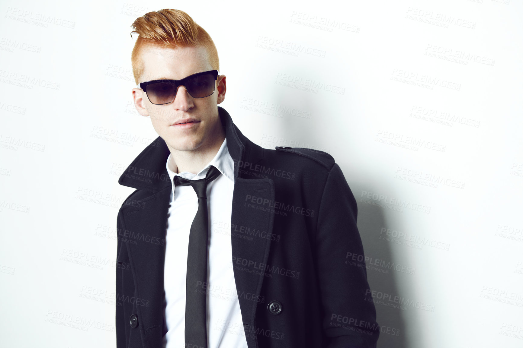 Buy stock photo A red haired male looking at the camera in a suit and sunglasses with a white background