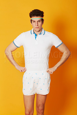 Buy stock photo A young male in retro tennis wear with his hands on his hips and looking at the camera