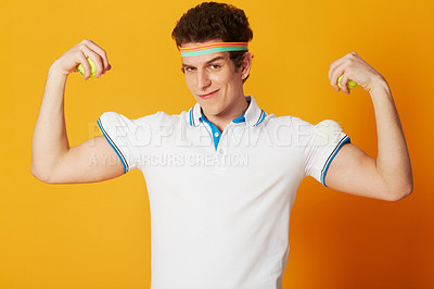 Buy stock photo A young man in tennis attire hiding tennis balls in his sleeve