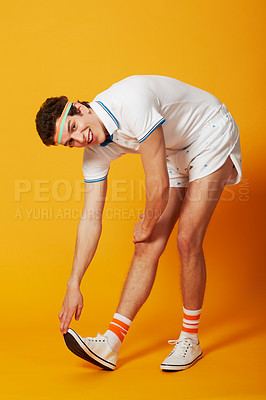 Buy stock photo A male stretching out his calf muscle in retro sports gear