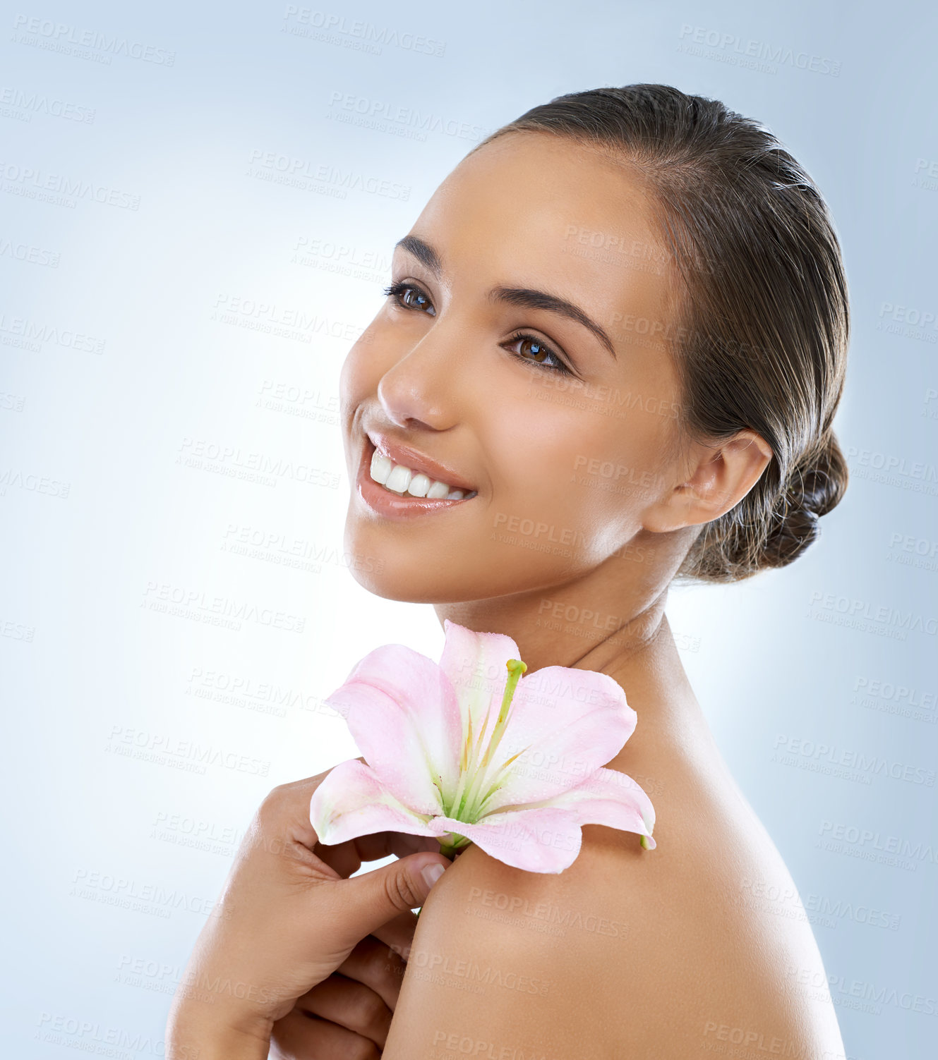 Buy stock photo Happy woman, face and flower in natural skincare, beauty or cosmetics on a blue studio background. Young female person smile with plant or petals on shoulder for glow, care or smooth skin on mockup