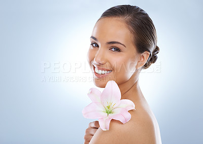 Buy stock photo Happy woman, portrait and flower in natural skincare, beauty or cosmetics on a blue studio background. Face of young female person smile with plant on shoulder for nature or glow on mockup space