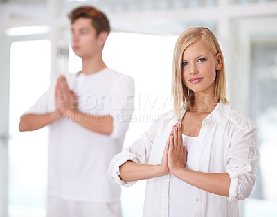 Buy stock photo Shot of two young people doing yoga together