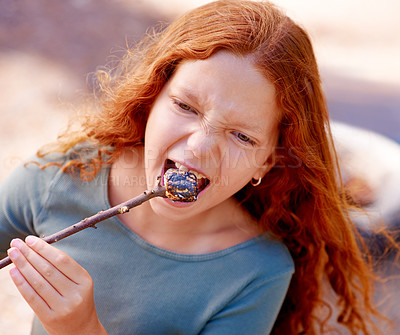 Buy stock photo Girl, marshmallow and eating in nature, camping holiday and fire for roast snack in forest. Red hair, teenager and hungry for chocolate candy with happiness and outdoor vacation in woods for kids