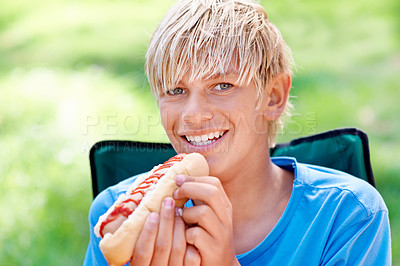 Buy stock photo Child, eating and portrait with hotdog outdoor in camping chair and relax at barbecue with lunch. Happy, kid and hungry for food from bbq in park, woods or forest on holiday or vacation in summer