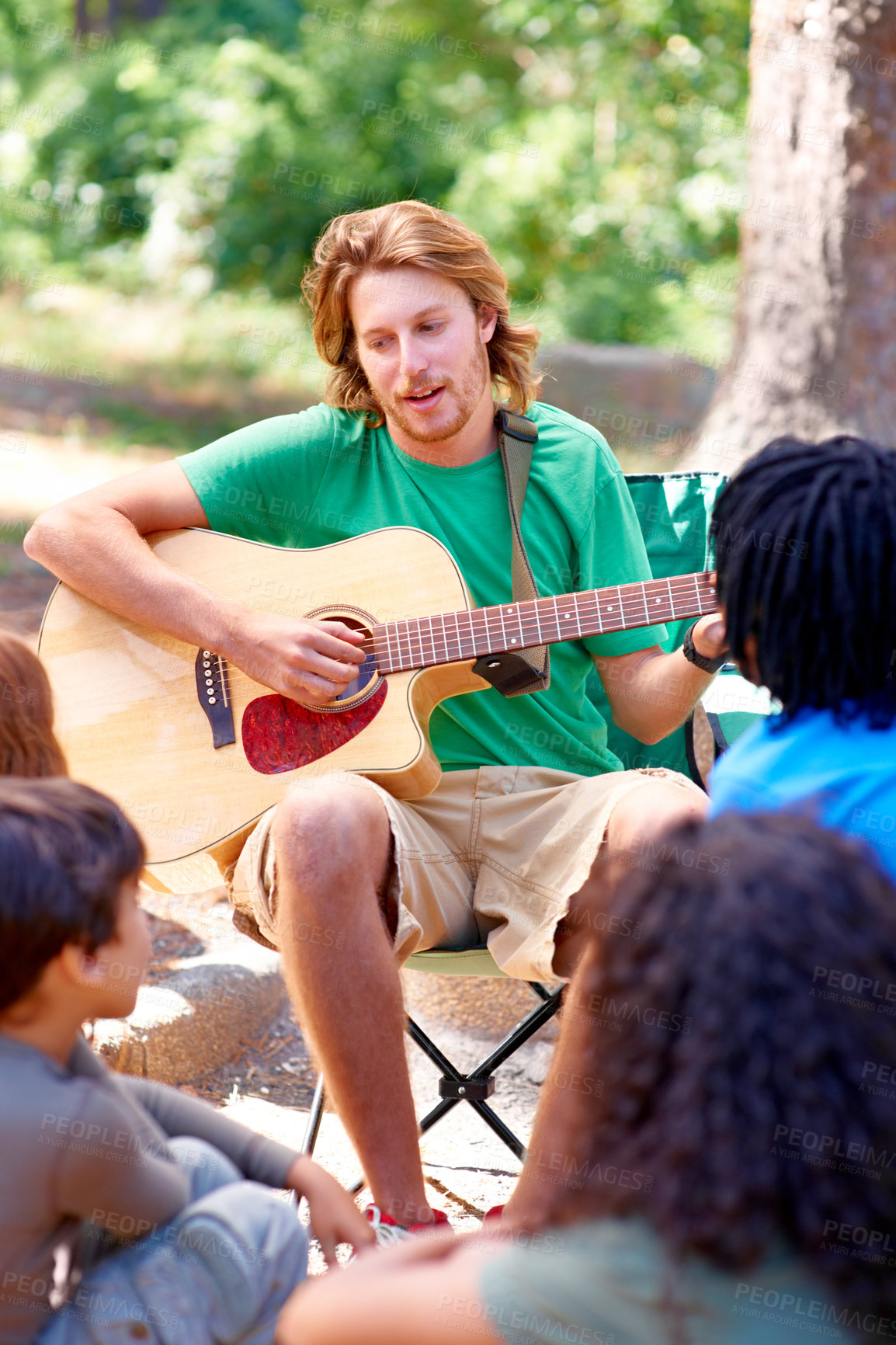 Buy stock photo Nature, camp and man playing guitar for entertainment, talent or music in woods or forest. Singing, musician and male person with acoustic string instrument outdoor in park or field on weekend trip.