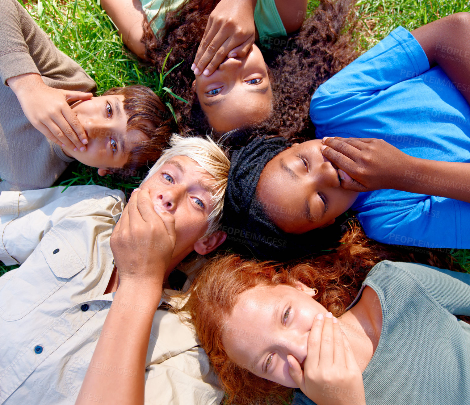 Buy stock photo Shock, secret and group of children outside in nature for holiday and leisure adventure. Joke, cover mouth and diverse kid best friends with gossip lying on grass for vacation for natural fun