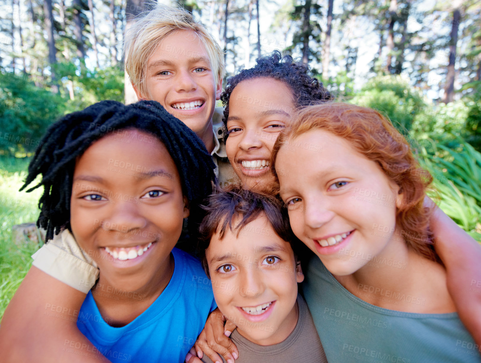 Buy stock photo A closeup of image of a group of kids smiling at the camera while standing in the woods