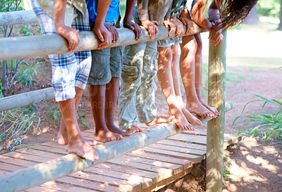 Buy stock photo Cropped view of a group of children balancing on a fence outdoors