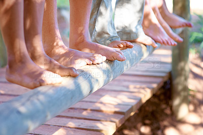 Buy stock photo Children, feet and closeup of balance on tree in nature for fun and adventure. Legs, zoom and diverse kids playing outside on wood with stability and support for development and friends bonding 