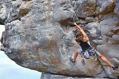 Buy stock photo A young rock climber scaling a mountain - copyspace