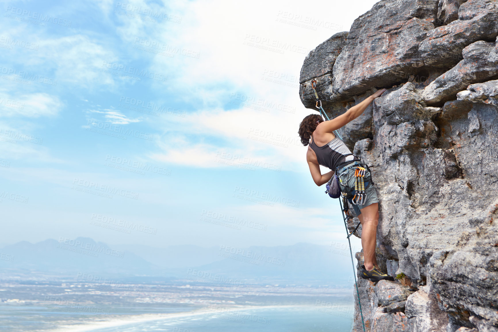 Buy stock photo Rock climbing, travel and blue sky with woman on mountain for adventure, cliff and space. Strong, freedom and mockup with female climber training in nature for courage, safety and workout challenge